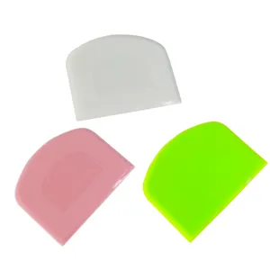 Detailed view of flexible plastic dough scrapers in white, pink, and bright green colors.