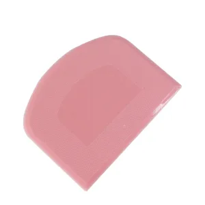 Pink plastic dough scraper for baking cakes, bench scraper pastry cutter kitchen tool detail.