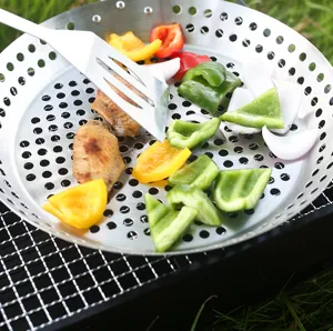 Stainless steel round BBQ grill pan with breathable holes for outdoor camping vegetables and meat.