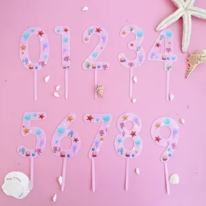 Pink acrylic number cake toppers with ocean seashell and starfish theme for birthday party.