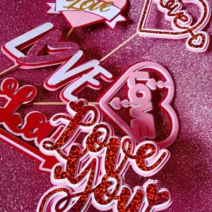 Valentine day glitter cake topper detail shot, showing paper heart love design clearly.