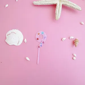 Pink acrylic number 9 cake topper detail, ocean theme birthday party decoration close-up view.