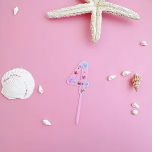 Pink acrylic number 4 cake topper detail with ocean seashell and starfish marine theme.