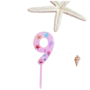 Detail view of the pink acrylic number 9 cake topper with cute ocean theme patterns.