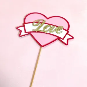 Valentine heart cake topper with glitter love text and wooden stick for party decoration.