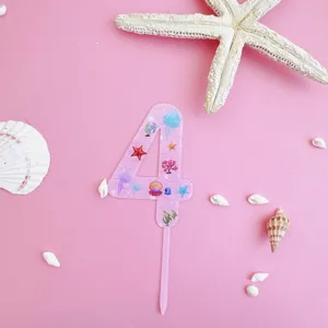 Detailed view of the pink acrylic number four cake topper featuring cute ocean sea life designs.