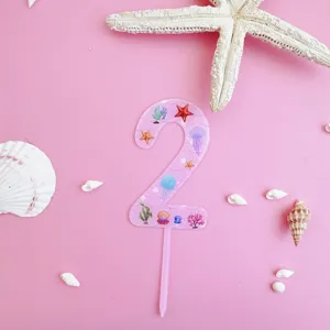 Pink acrylic number 2 cake topper with ocean marine themes like starfish and shells for birthday.