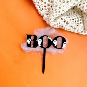 Halloween acrylic cake topper detail shot featuring black ghost design and BOO letters.