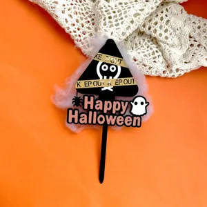 Close-up detail of Halloween acrylic cake topper with spooky ghost spider warning sign decor.