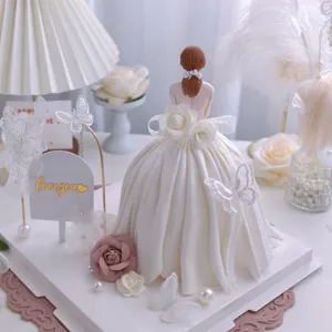 Vista dettagliata di un elegante set topper per torta con statuetta e farfalle di pizzo.