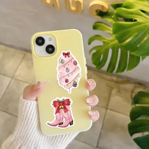 Detailopname van een gele telefoonhoes versierd met schattige roze kerststickers.