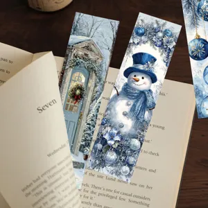 Detail view of blue Christmas paper bookmarks with snowman and winter scenery for reading.