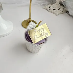 Primer plano detallado del adorno para pastel de cumpleaños de acrílico dorado en cupcake.