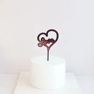 Detailed view of red and black acrylic heart love cake topper on white dummy base.