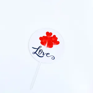 Valentine acrylic cake topper detail featuring red hearts and love script design.