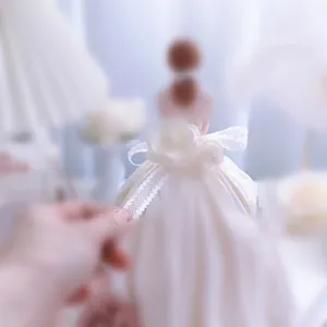 Vista dettagliata di elegante topper per torta dea con abito in pizzo delicato e design.