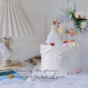 Set topper per torta di compleanno con elegante statuetta femminile e decorazione floreale dorata.