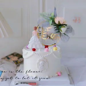Set decorazione torta Festa della Donna con statuetta sposa e topper acrilico dorato.