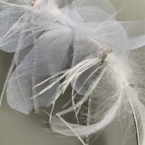 Nahaufnahme Detail von weißem Feder Tüll Schleife und funkelnden Strasskette Kuchendeko.