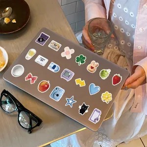Detail shot of cute aesthetic laptop stickers featuring various summer fruits and small items.