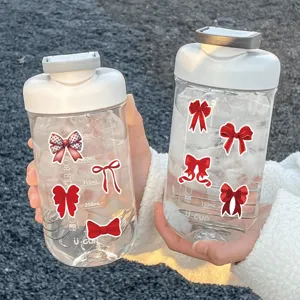 Clear plastic shaker water bottle decorated with cute red bow stickers and volume scales.