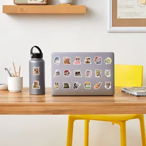 Detail view of cute realistic cat meme stickers decorated on laptop and water bottle.