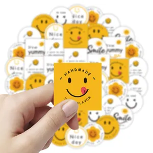 Detail closeup view of cute cartoon smiley face baking packaging sticker held by hand.