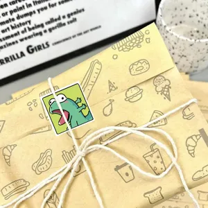 Close-up detail of cute cartoon sticker on brown craft paper gift package with white twine.