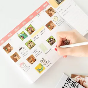 Detailed view of a cute cartoon weekly planner notepad with daily schedule notes and stickers.