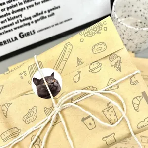 Close-up detail of cute realistic cat sticker on craft paper packaging roll with rustic twine.