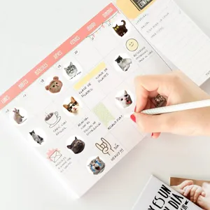 Detail shot of cute realistic cat stickers decorating a daily planner on a clean desk.