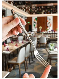 Detailaufnahme einer Edelstahl-Kaffeegabel mit elegantem Kürbisgriff im Restaurant.