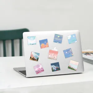 Close-up detail view of healing oil painting style landscape stickers on white laptop.
