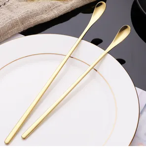 Stainless steel long handle mixing spoon detail, elegant gold finish for coffee and dessert.