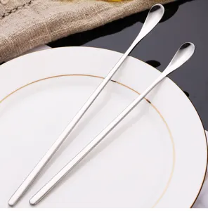 Detailed shot of minimalist long-handled stainless steel spoons for coffee mixing and desserts.