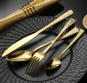 Elegante detalle de cubiertos de acero inoxidable dorado con mango texturizado de corteza.