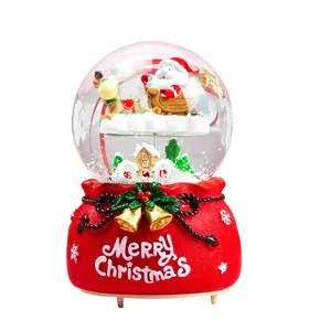 Christmas snow globe music box featuring Santa Claus and reindeer in a festive red sack base.