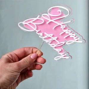 Détail de cake topper Joyeux Anniversaire en acrylique, design double couche rose et blanc.