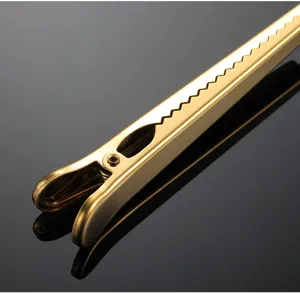 Detail view of a golden stainless steel sealing clip handle, durable kitchen baking tool.