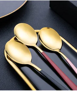 Close-up detail view showing stainless steel spoons with colorful handles and golden bowls.