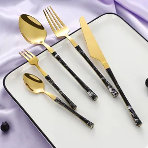 Gold stainless steel flatware set with marble handles, luxury western tableware on display plate.