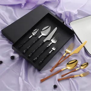 Stainless steel flatware set with marble and wood grain handles for luxury dining table decor.