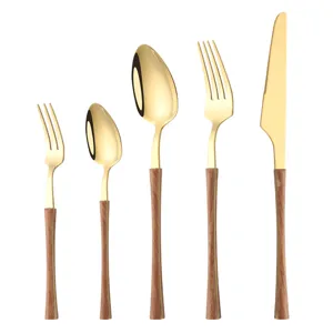 Gold stainless steel flatware set with wood grain handles, elegant cutlery for dining table.