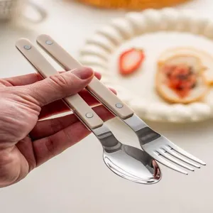 Ensemble cuillère et fourchette en acier inoxydable, poignées ABS beiges, design de coutellerie.