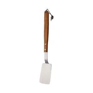 Stainless steel small spatula with wooden handle for kitchen cooking, steak and eggs.