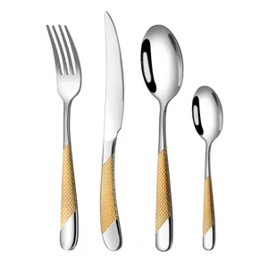 Stainless steel flatware set with gold textured handles, ideal for modern tables.