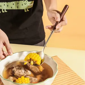 Stainless steel soup ladle with ergonomic wooden handle kitchen utensil for cooking and serving.