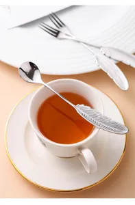 Vue détaillée de la cuillère à café en acier inoxydable à poignée plume, élégante présentation thé.