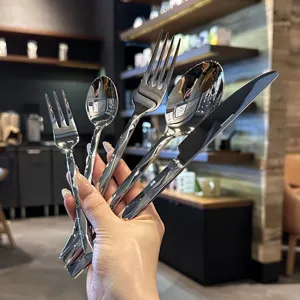 Stainless steel cutlery set detail shot, luxury hotel style diamond cut mirror polish silverware.