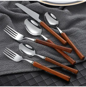 Detail view of Japanese style stainless steel cutlery set with wooden handles, elegant tableware.